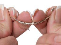 Hands bending wrapped wire